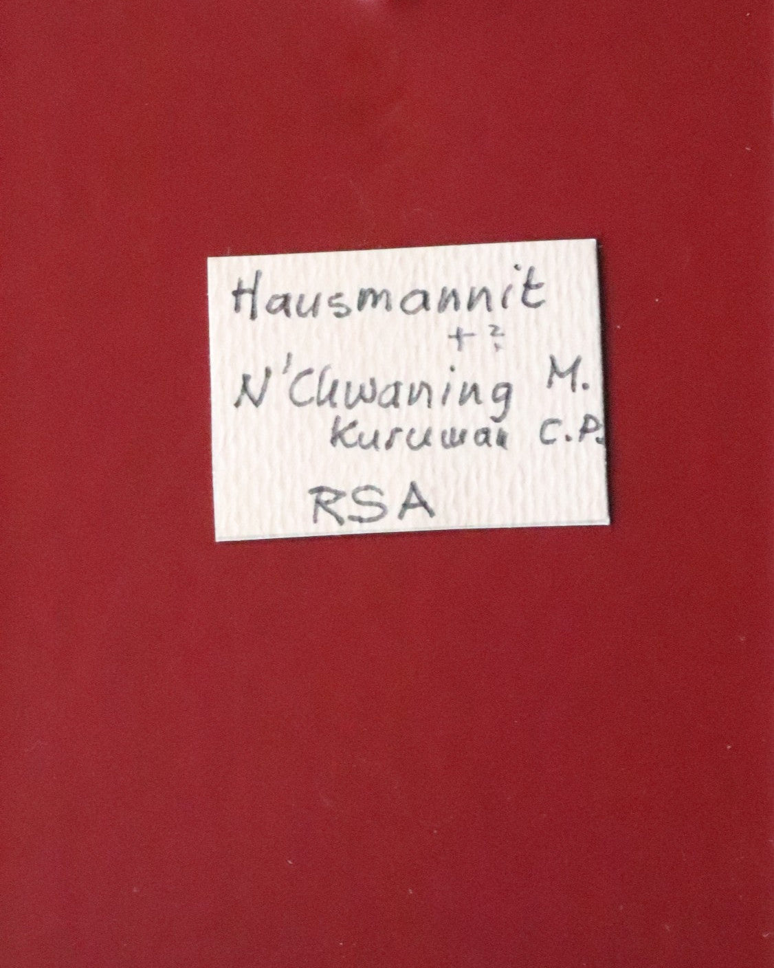 Front label of Hausmannite thumbnail from N'Chwaning, South Africa. Ex. Clive Queit.