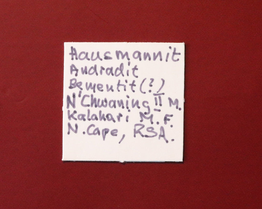 Front of label for Hausmannite with Andradite and possibly Bementite from N'Chwaning II, Kalahari Manganese Fields, South Africa