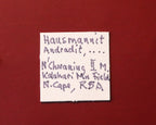 Front of label for Hausmannite with Andradite and possibly Bementite from N'Chwaning II, Kalahari Manganese Fields, South Africa