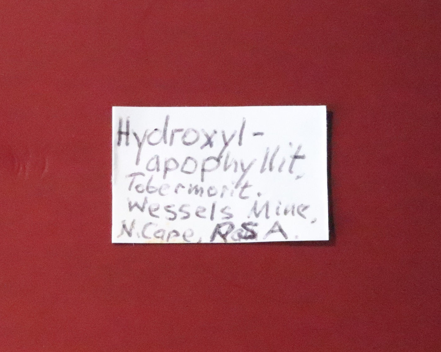 Front of label for Hydroxyapophyllite with Tobermorite from Wessels Mine, South Africa. 