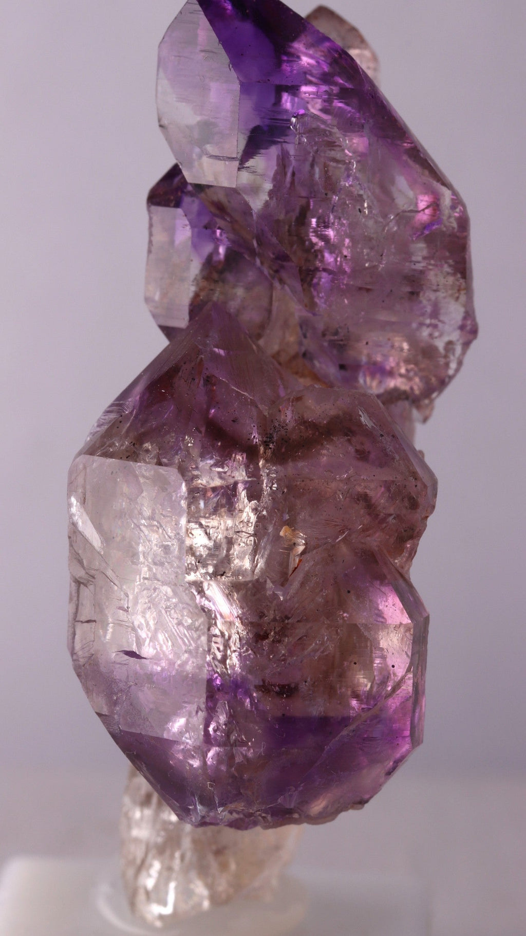Close-up of Amethyst sceptres on a Quartz point showing crystal termination and color zoning