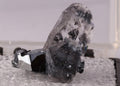 Front view of a cute Calcite, Hematite and Gauderfroyite thumbnail combination from N'Chwaning, South Africa