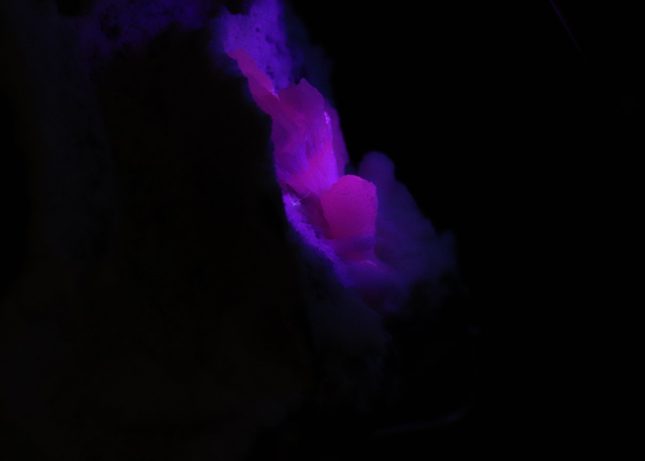 Close-up side view of fluorescent Mangano-Calcite mineral specimen from N'Chwaning II, Kalahari Manganese Fields, South Africa
