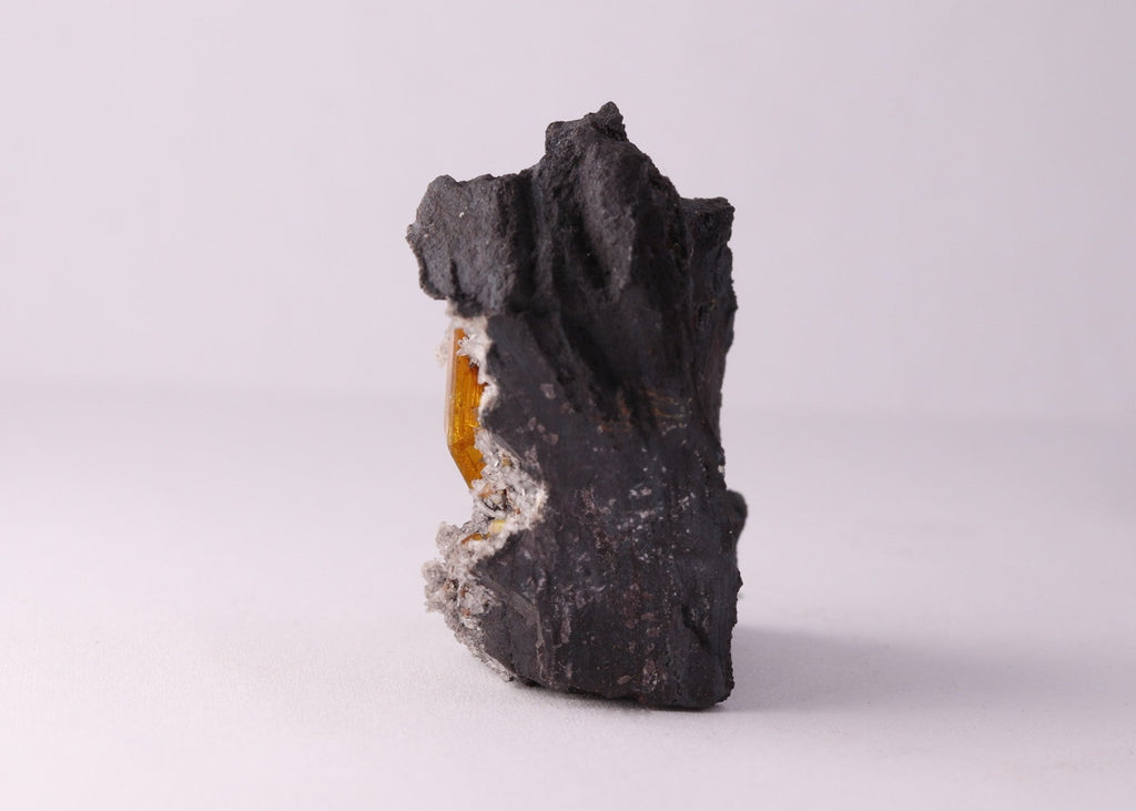 Side view of large gemmy Sturmanite crystal with Calcite on matrix from KMF (Kalahari Manganese Field), South Africa.