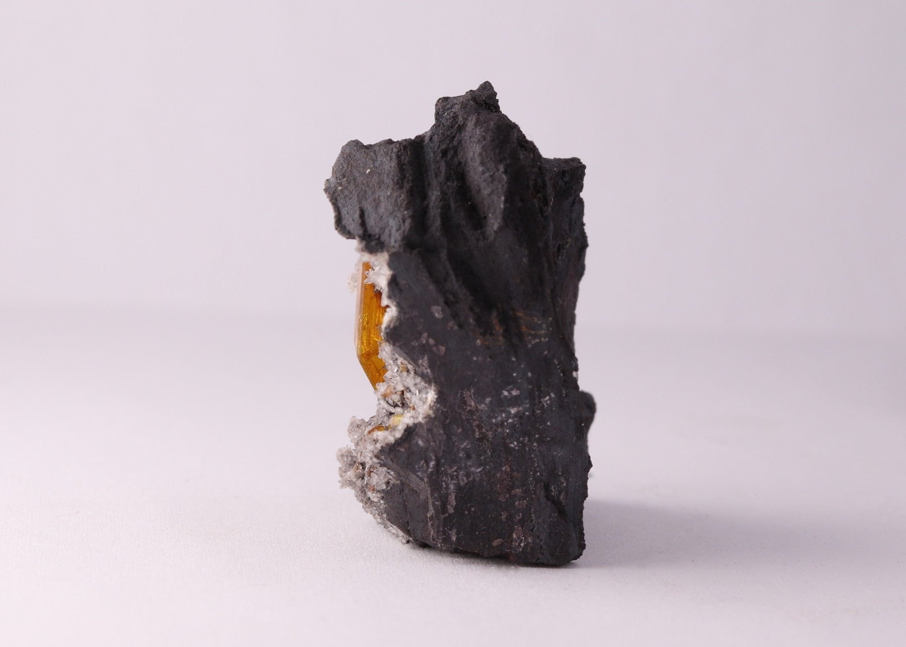 Side view of large gemmy Sturmanite crystal with Calcite on matrix from KMF (Kalahari Manganese Field), South Africa.