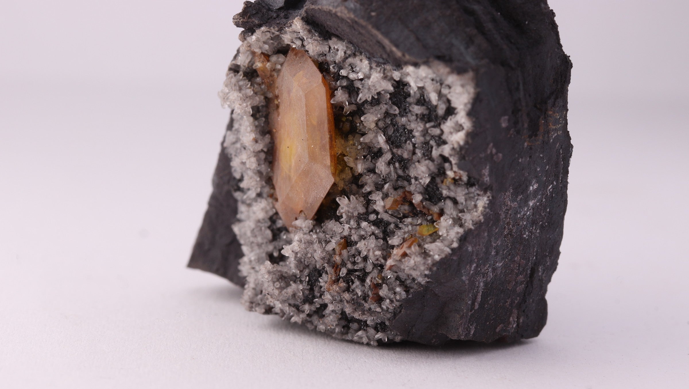 Close-up side view of large gemmy Sturmanite crystal with Calcite on matrix from KMF (Kalahari Manganese Field), South Africa.